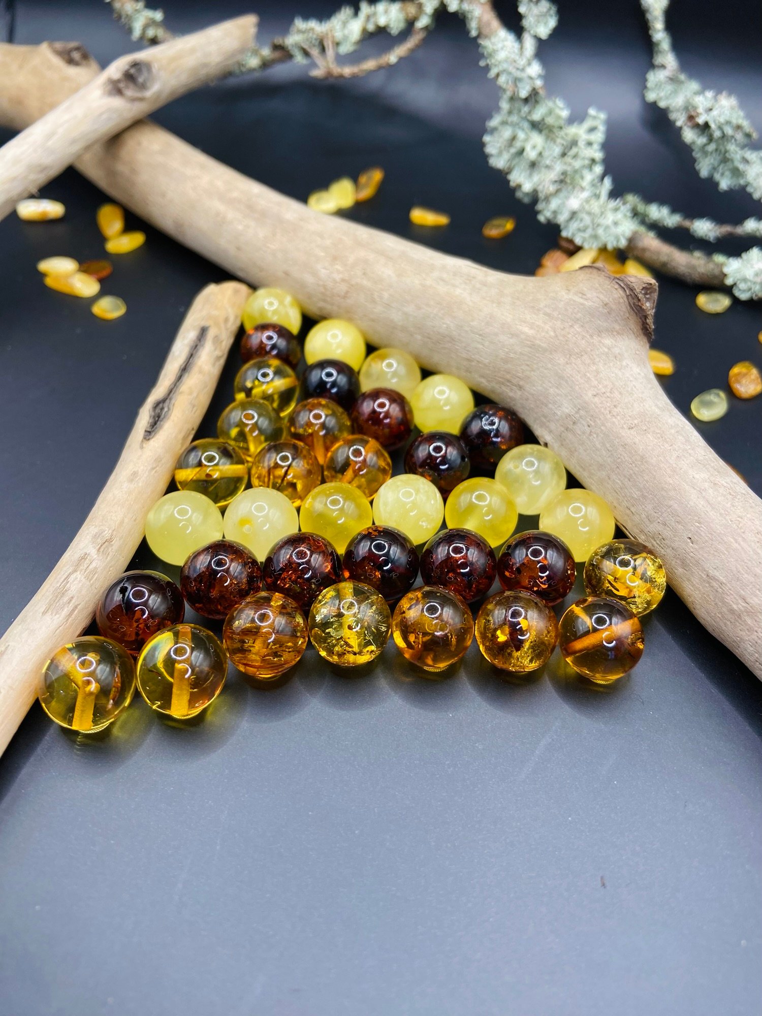 Various colours amber beads neatly placed between driftwood