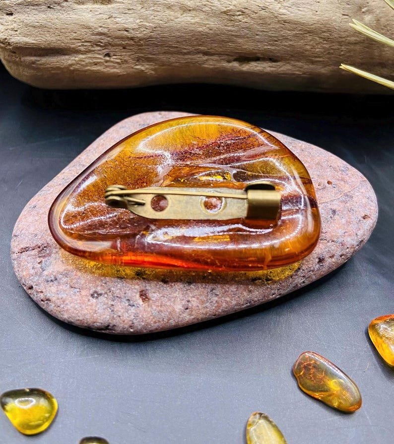 56548094-r-il-ca6f4a-7084638103-il_794xN.7084638103_63vn Skaistas konjaka kŗasas, vidēja izmēra Dzintara brošas