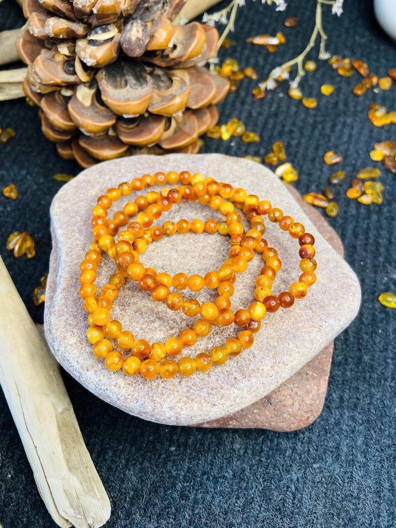 56548094-r-il-835286-6836957809-il_794xN.6836957809_js7t Ugunīgā Baltijas Dzintara apaļo pērlīšu aproce