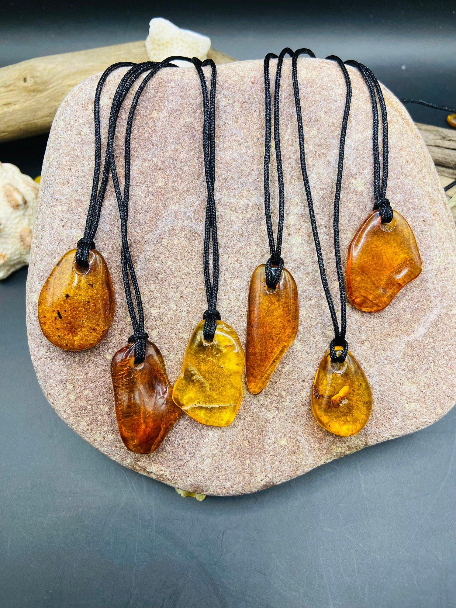 img_2752.jpg Pulēti Dzintara kuloni ar melnu neilona aukliņu