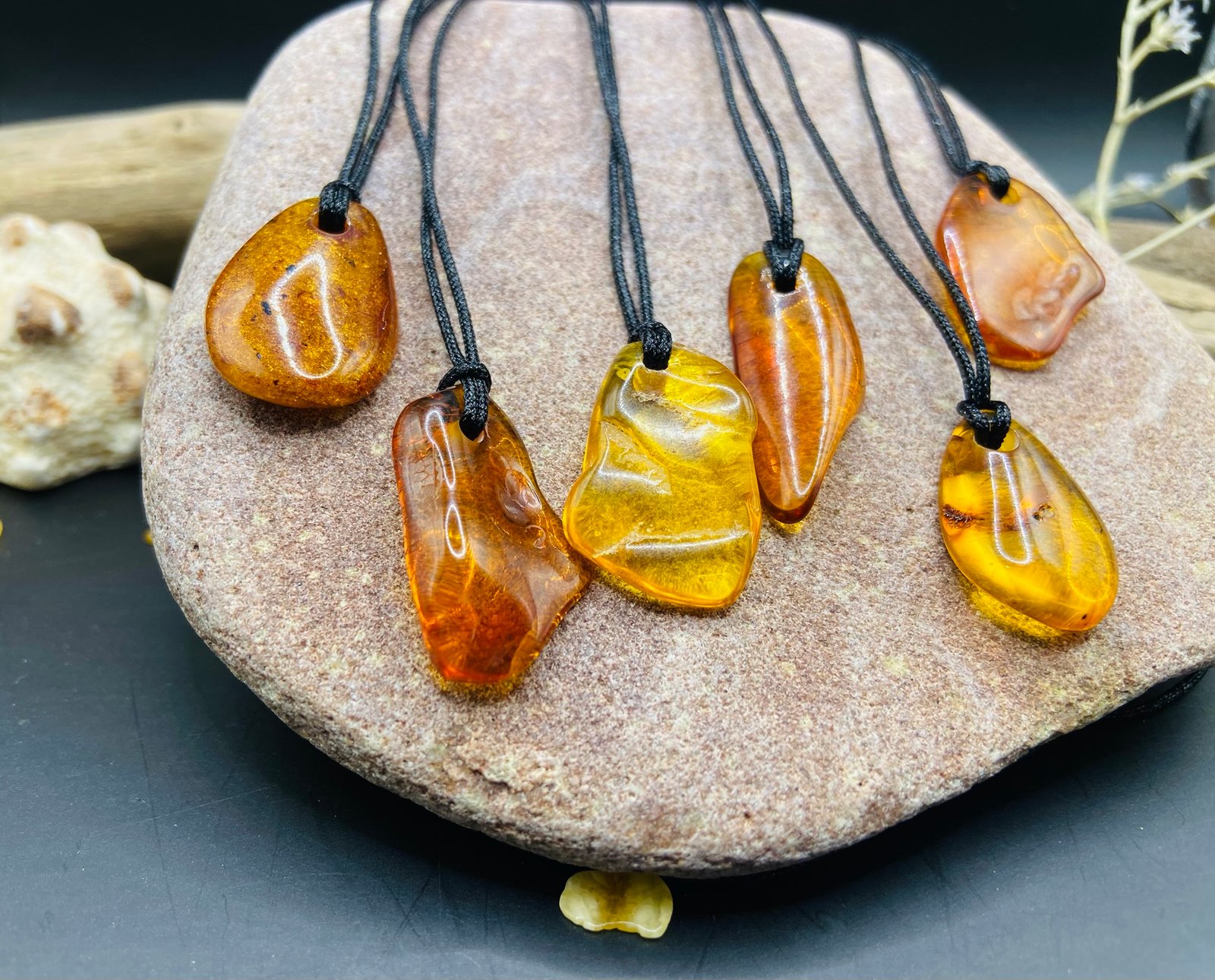 img_2753.jpg Pulēti Dzintara kuloni ar melnu neilona aukliņu