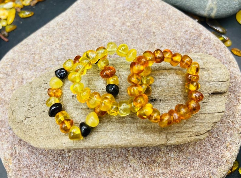 Minimālisma burvība trīs krāsu dzintara pulētos gredzenos