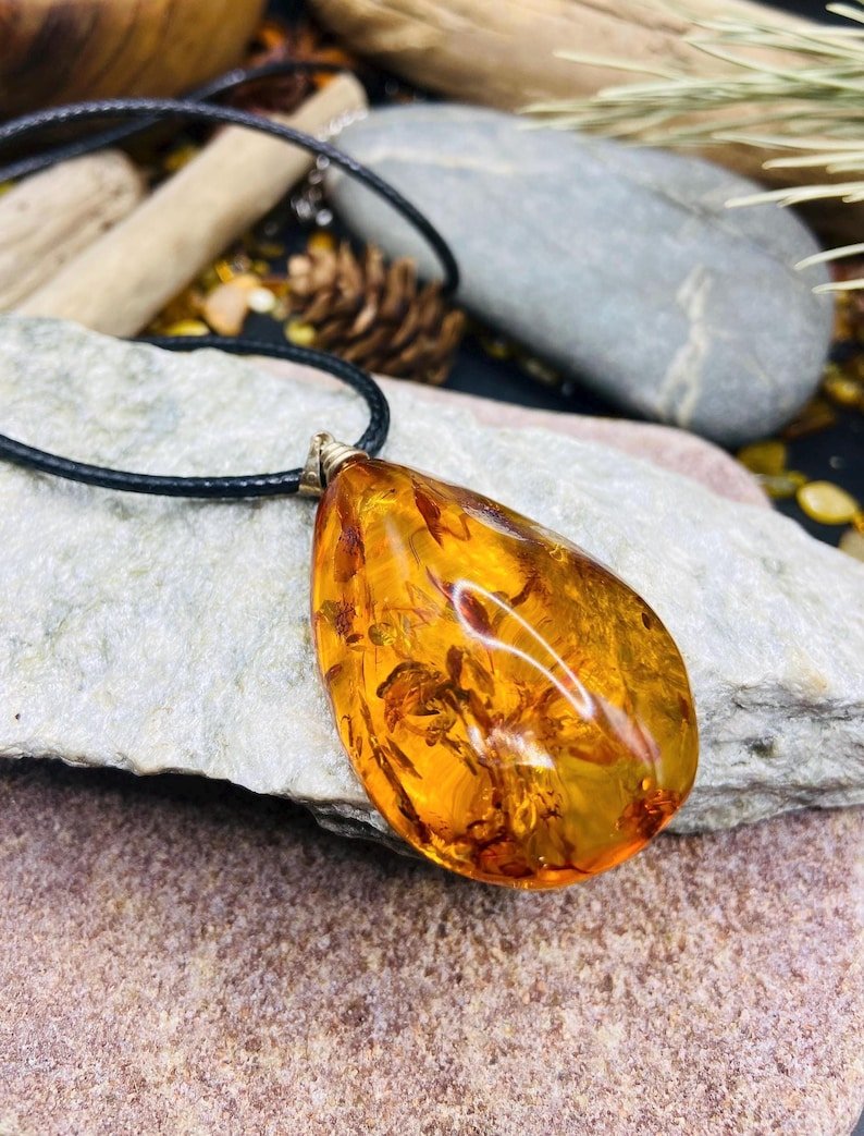 Īpašs Dzintara kulons ar neticamiem ietvērumiem un pulētu virsmu