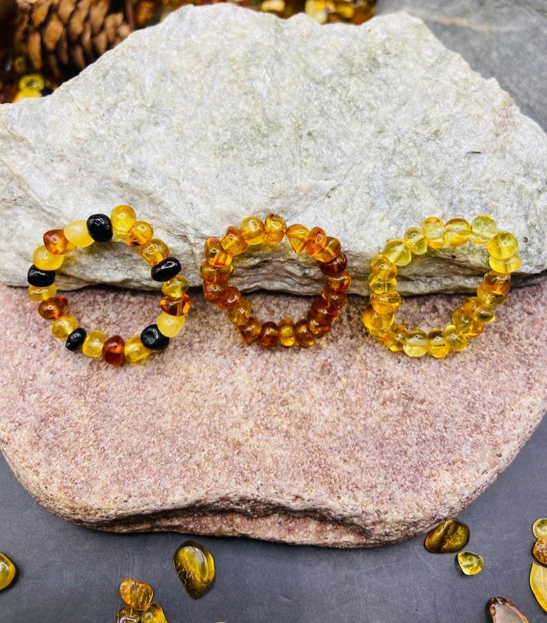 Minimālisma burvība trīs krāsu dzintara pulētos gredzenos