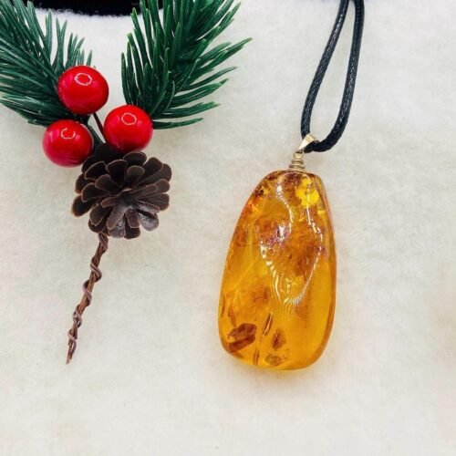 Oranžas krāsas pulēts Baltijas Dzintara kulons ar melnu aukliņu