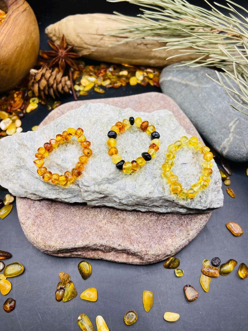 Minimālisma burvība trīs krāsu dzintara pulētos gredzenos