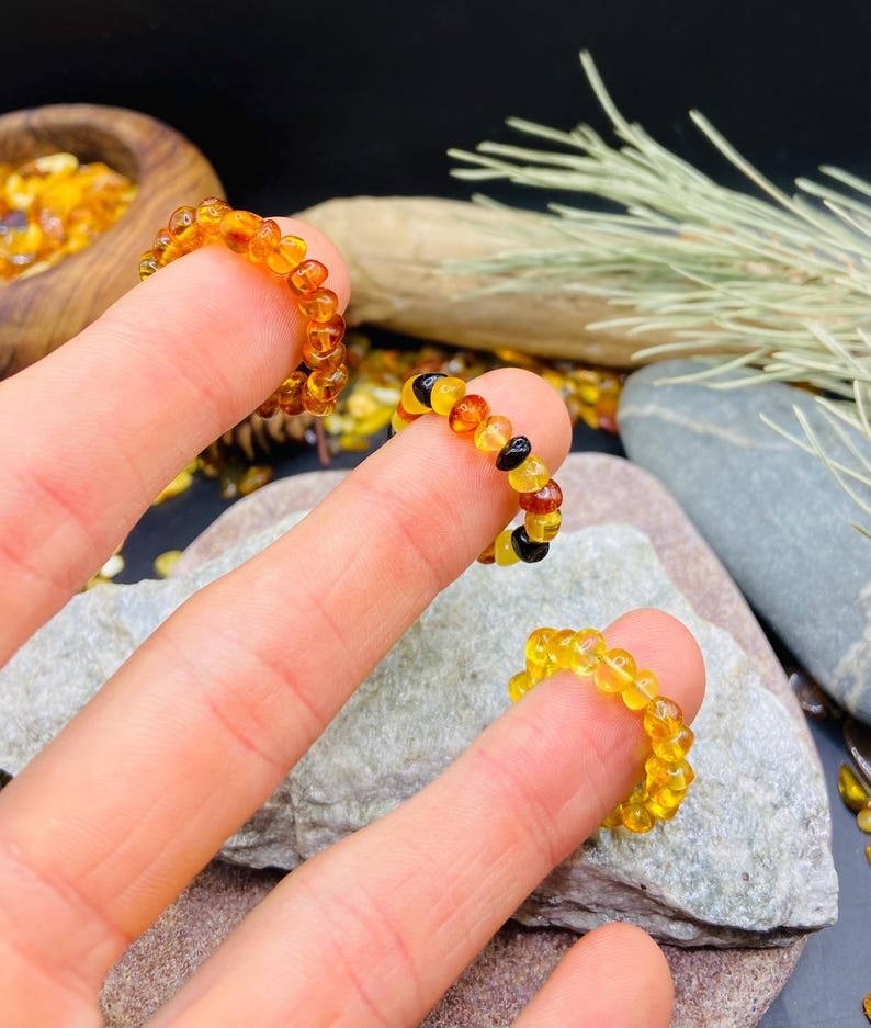 Minimālisma burvība trīs krāsu dzintara pulētos gredzenos