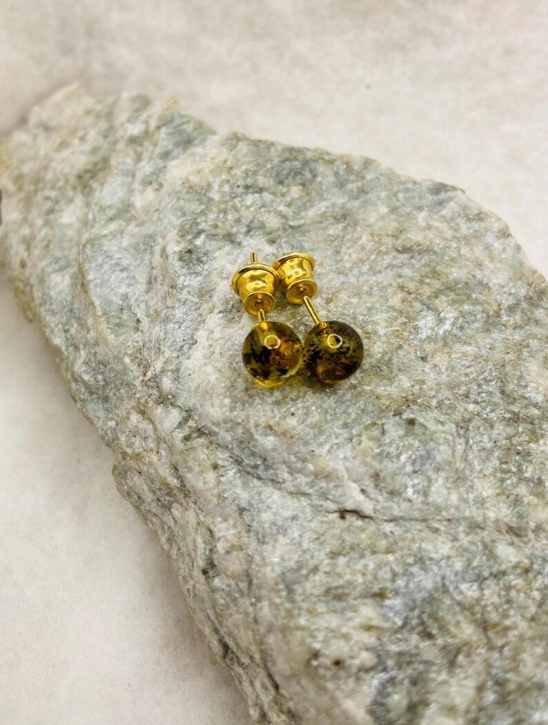 Zaļganas krāsas Dzintara duramie auskari ar apzeltītām kājiņām