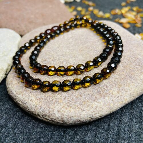 Tumša fasētā dzintara kaklarota, kas maina krāsu